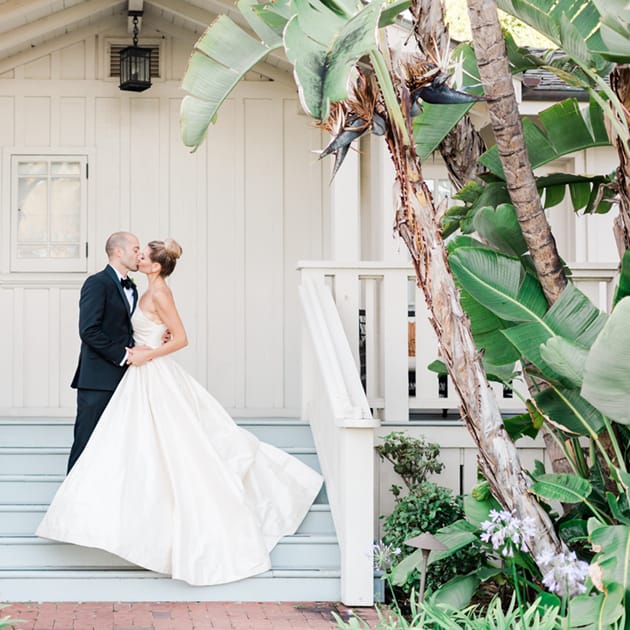 Ria and Stephen kissing under palm trees at El Encanto, A Belmond Hotel Santa Barbara