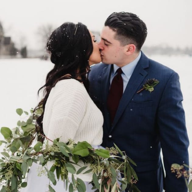 field/wibride_com_239elwb01_blackmesh_com/2018/image/866x578px.bride_and_groom_kissing_with_green_leaves_snowy_day_WEB.jpg