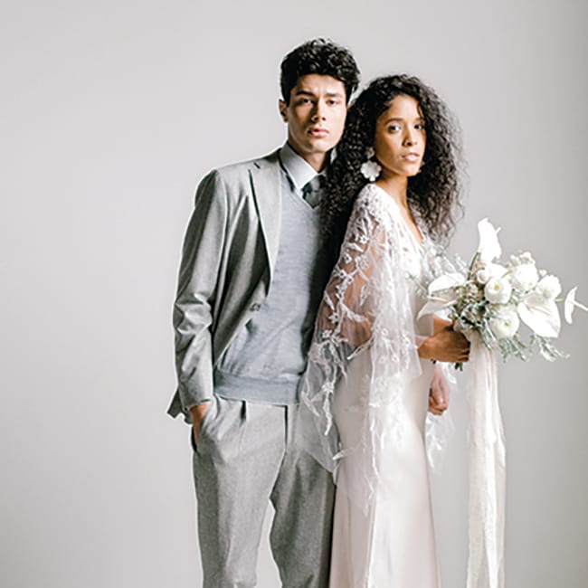 Grays and stark whites make up the bride and groom's attire
