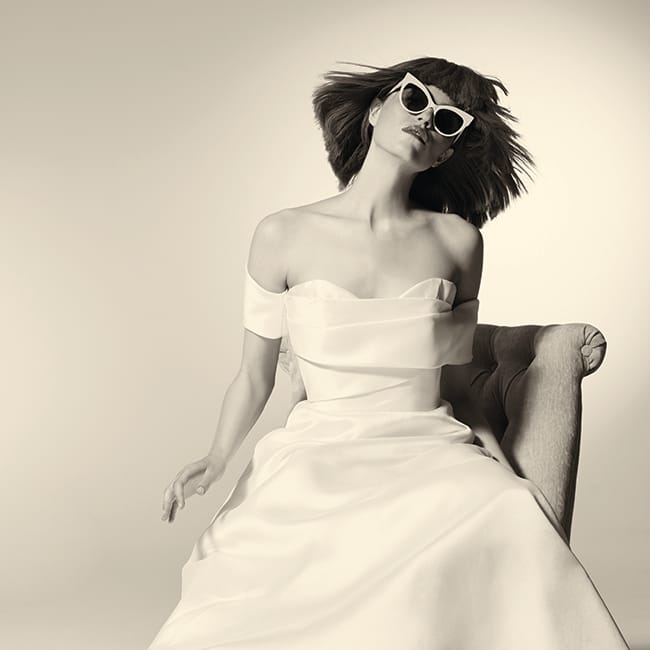 A minimalist gown silhouette, cat-eye sunglasses and a blunt bob adorn this bride