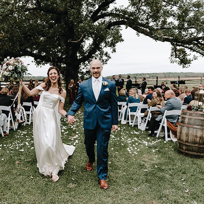 Caroline Grassl and Miles Groeschel walk down the aisle at their Sugarland Barn wedding.