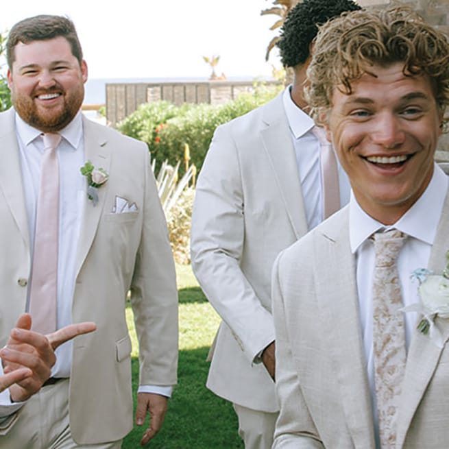 Groomsmen smile and pose playfully 