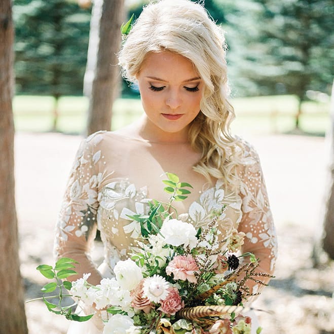 Ashley Zelenka holds her bouquet at her rustic camp wedding.
