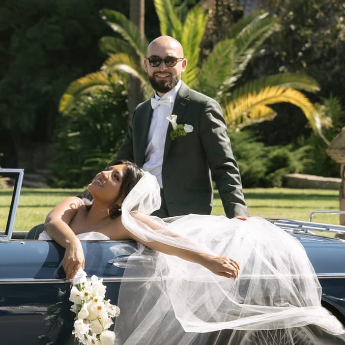 Cristabel and Martin pose in their vintage getaway car outside of the Santa Barbara Courthouse