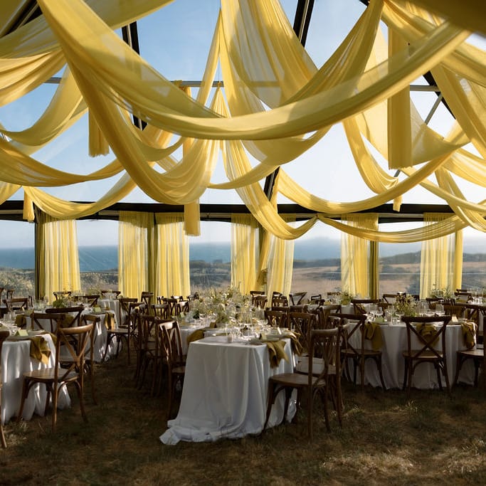Bold chartreuse draping frames modern outdoor reception dinner at The Sea Ranch Lodge