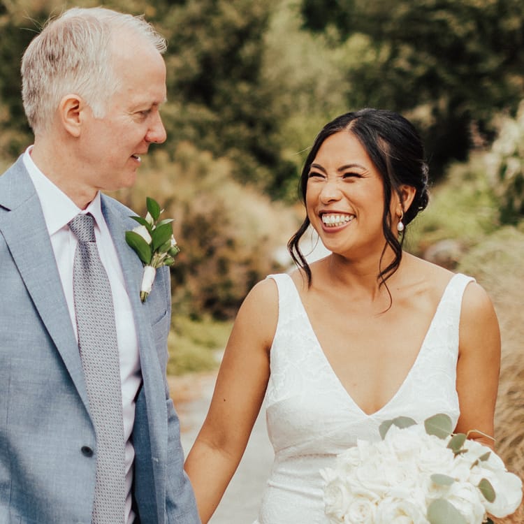 Bride and groom walking holding hands and looking at each other at Seattle Pacific Connections Garden at Washington Park Arboretum