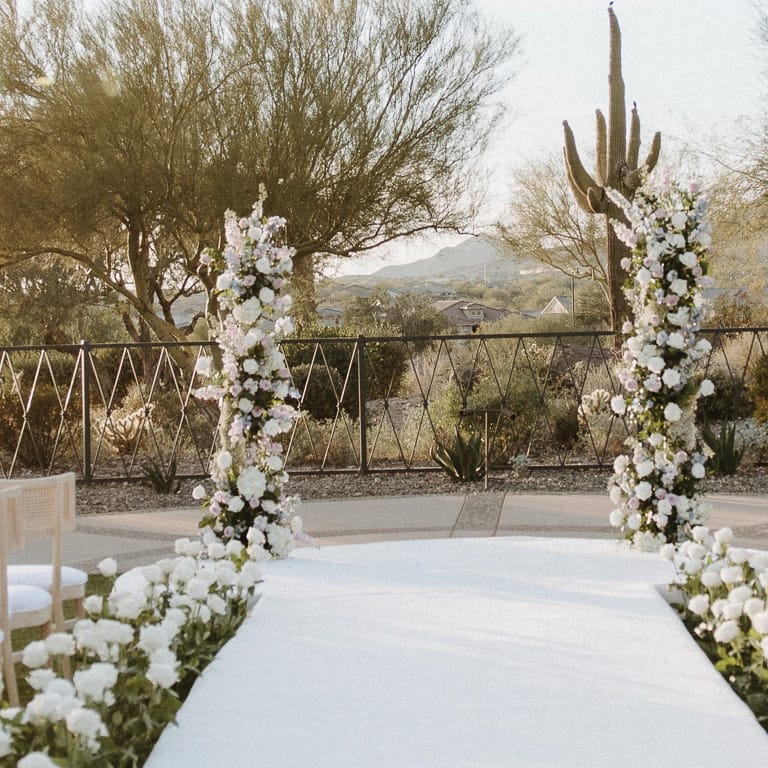 Ceremony space looking over Peoria's native plants, white roses lining the aisle