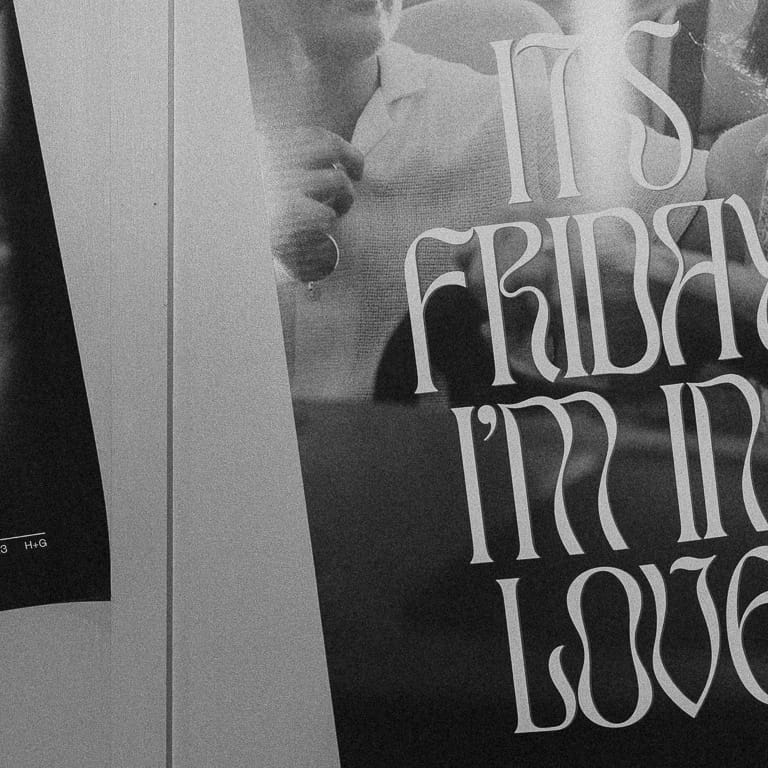 Black and white wedding sign reading 'It's Friday, I'm in Love' displayed at Hannah and Gunnar's garden-themed wedding reception at Historic 1625 Tacoma Place