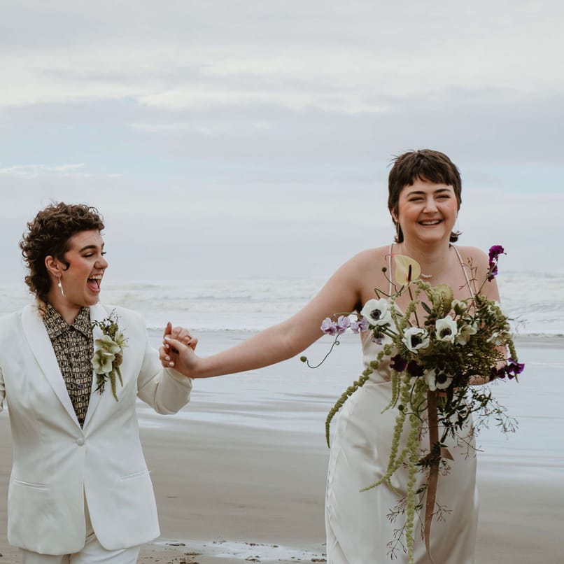 Couple walk together hand in hand in intimate elopement on Cannon Beach