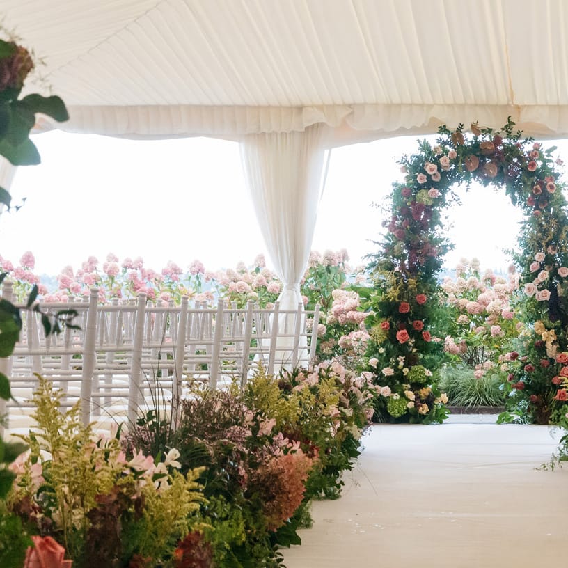 Floral lined aisle and altar in tented ceremony at Woodmark Hotel & Still Spa