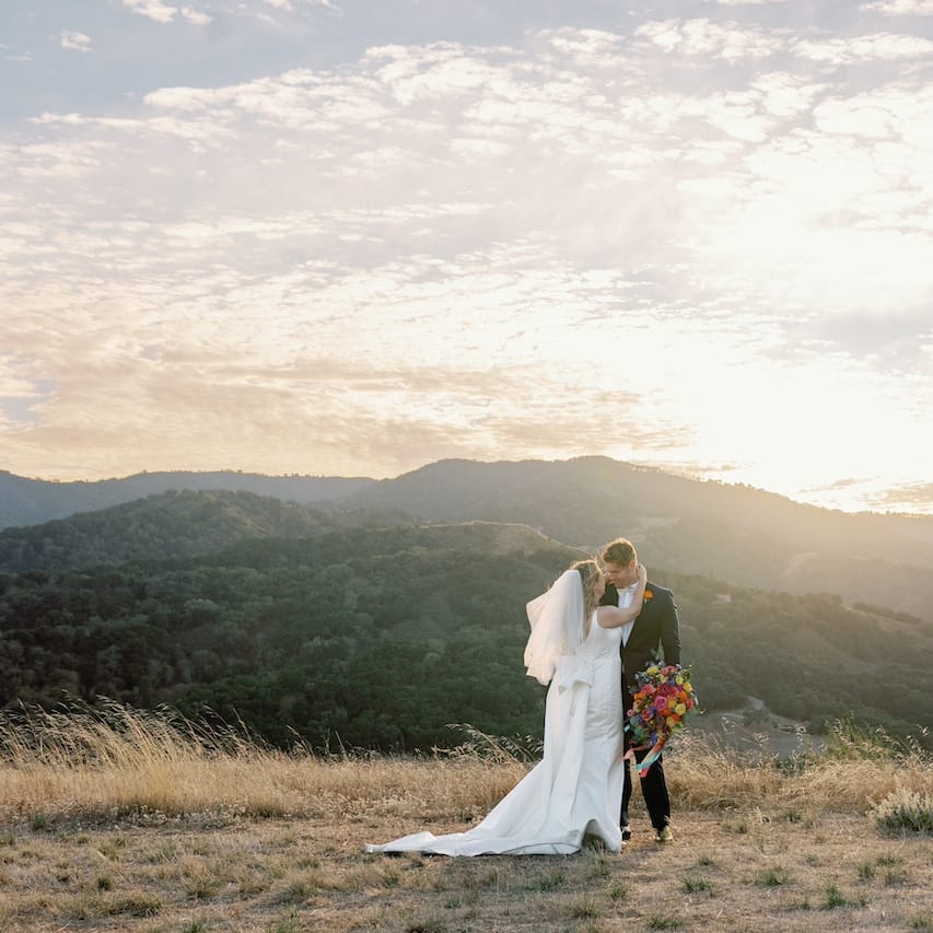 Katie and Sam Overlooking the Mountainous Santa Lucia Preserve in Colorful Wedding