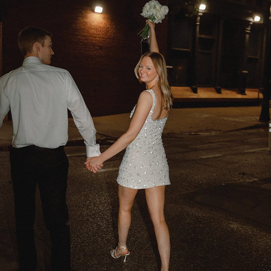 Bride and groom holding hands at their reception